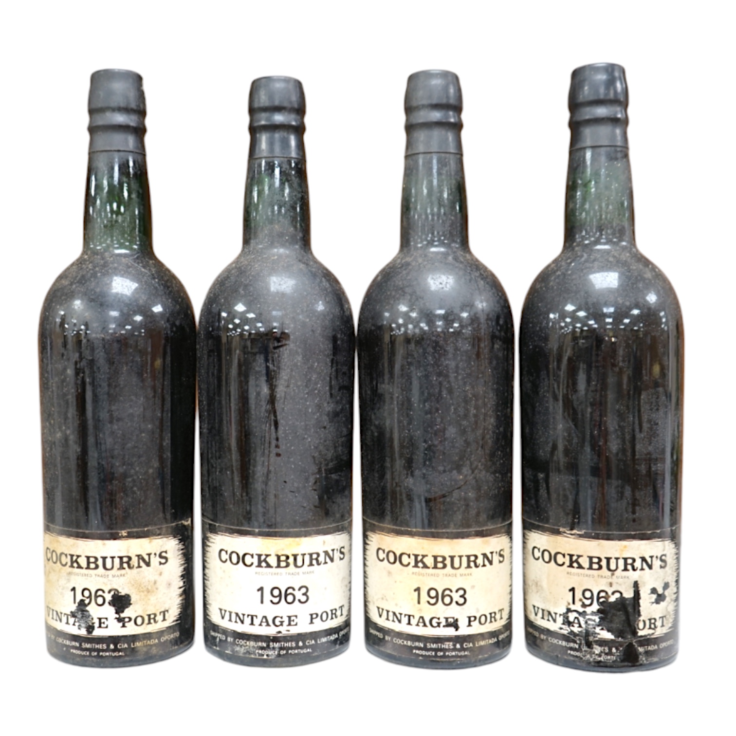 Four bottles of Cockburn’s 1963 vintage port. Condition fair, some wear to labels.